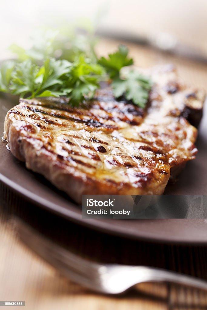 pork chop juicy grilled pork chop (neck cut) with greens Barbecue - Meal Stock Photo