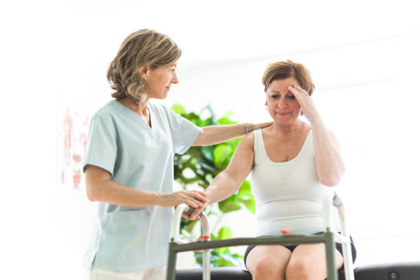 istock Physiotherapist working with elderly patient in clinic 1556308399