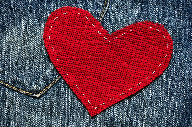 roten herz mit jeans-hintergrund - red stitches stock-fotos und bilder