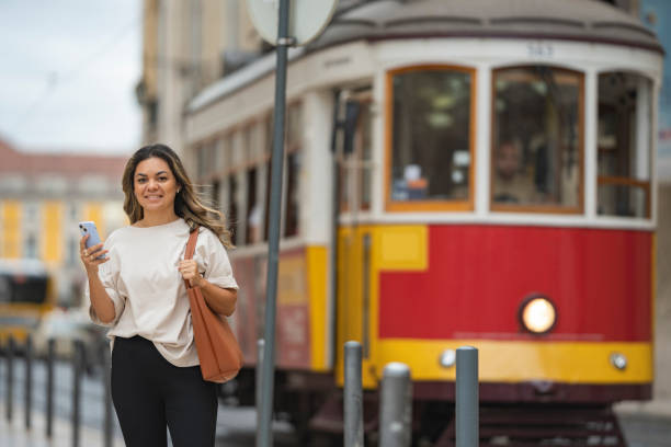 istock Tourist holding smartphone and looking at camera in Lisbon 1556357353