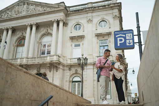 Mature couple using smartphone outside building in Lisbon