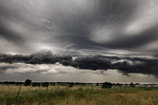 Thunderstorm over meadows and large cumulonimbus thundercloud and rain