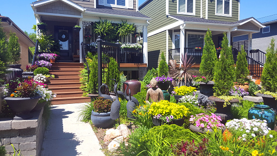 Regina,Saskatchewan, Canada- July 1,2023:  Front yards of two homes showing amazing examples of gardening with pots.