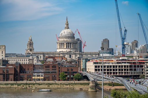 A view on a sunny day of the London icon, St Paul's Cathedral, towering across the river Thames.