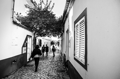 Ferragudo, Portugal- October 20, 2022: Narrow Cobblestone streets and typical Portuguese facades in Ferragudo town, Portugal