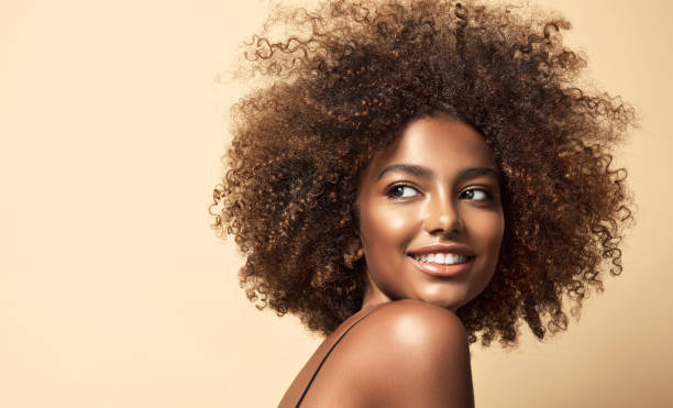 Wide toothy smile and expression of pleasure on the face of young brown skinned woman. Natural Afro hair. stock photo