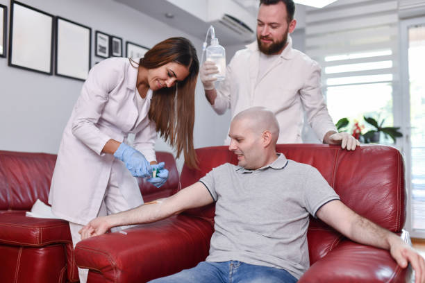 istock Stressed Male Cancer Patient Calming Down After Needle Is Inserted During IV Drip Chemotherapy 1556468411
