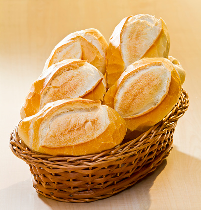 Basket of bread on a wooden table, French bread