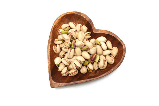 istock Pistachios on a heart shaped plate isolated on a white background. 1556494136