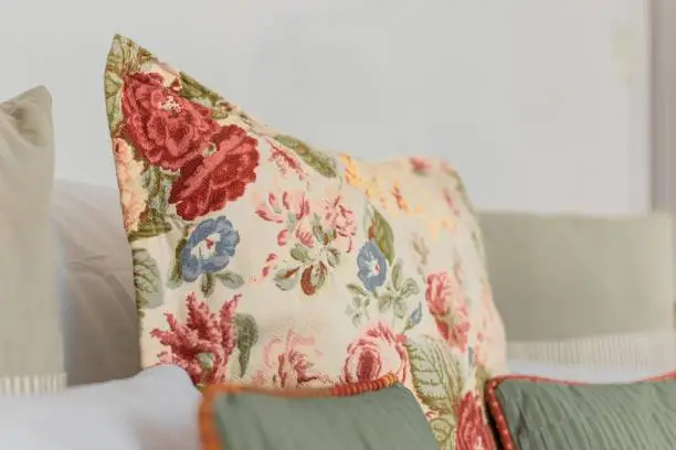 A close-up of a gorgeous vintage-style pillow with flower embroidery on it placed on a couch