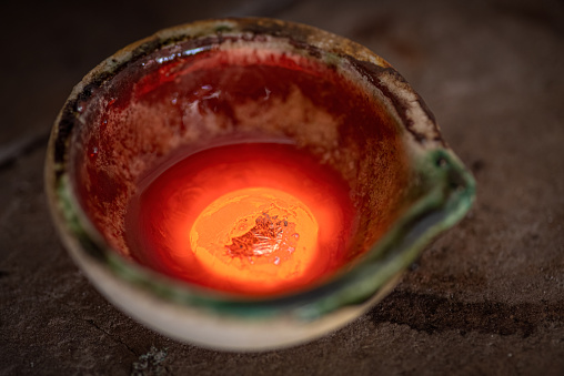 Jeweler melting gold in crucible with gasoline burner