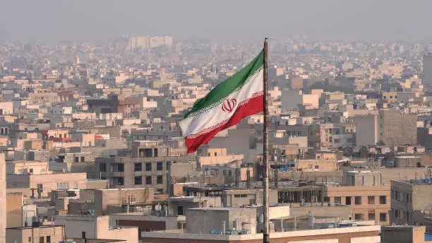 The city of Tehran with the waving Iranian Flag in the foreground