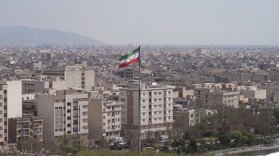 The city of Tehran with the Iranian Flag waving in the middle