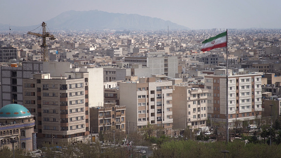 The city of Tehran with the waving Iranian Flag in the foreground