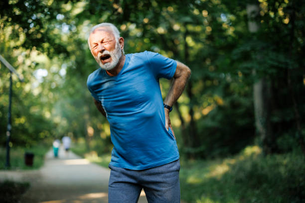 istock Sporty senior man having back pain while jogging 1556561400