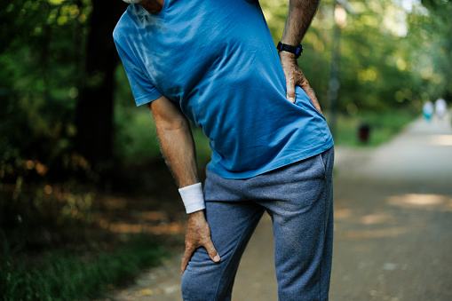 Senior man runner with knee pain in the park