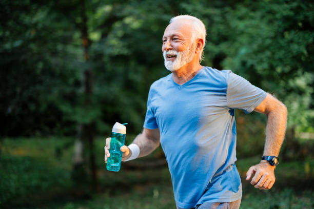 istock Sporty senior man jogging in nature park 1556564761
