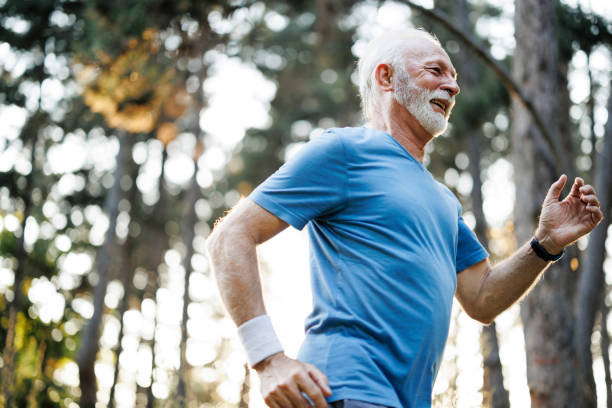 istock Sporty senior man jogging in nature park 1556566794