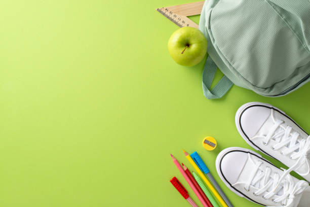 istock An eye-catching image of a backpack, sneakers and stationery viewed from above on a light green isolated background. Suitable for educational marketing materials and text placement 1556576670