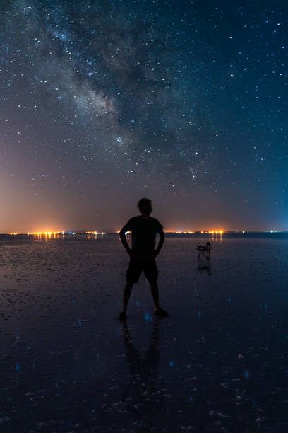 istock Young man looking at Milky Way view in Salt Lake. 1556589985
