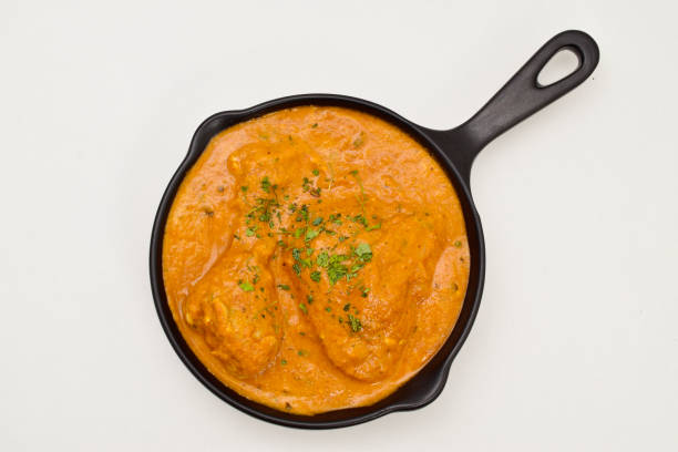 istock Top view of butter chicken on white background 1556592118