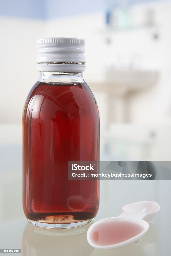 Cough medicine on bathroom shelf Cough medicine and spoon on bathroom shelf Cough Medicine Stock Photo