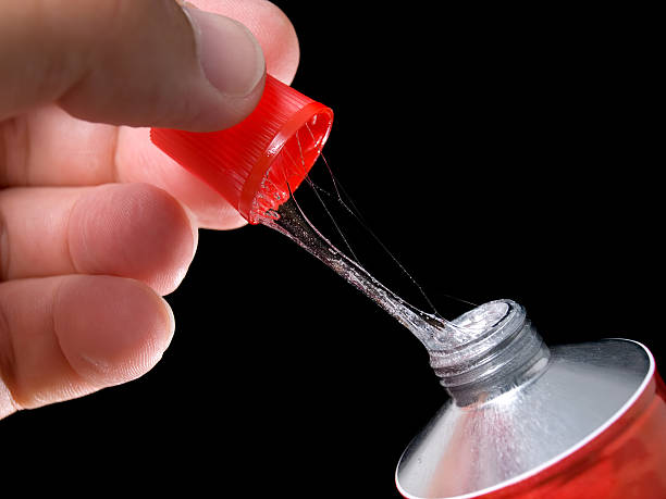 Sticky glue Closeup view during the opening of the glue tube. stickler stock pictures, royalty-free photos & images