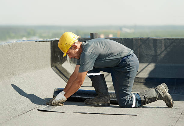 Flat roof covering works with roofing felt Roofer preparing part of bitumen roofing felt roll for melting by gas heater torch flame waterproof stock pictures, royalty-free photos & images