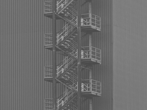 This picture was shot in Dusseldorf, Germany, in late March, 2023 and depicts an emergency staircase, in the back of an industrial facility.