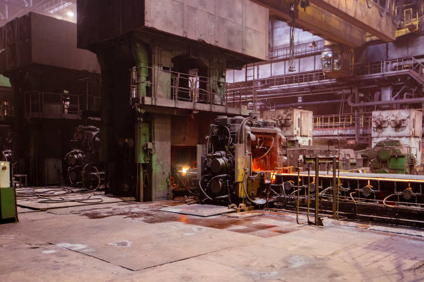 istock Rolled metal factory hot steel bar on conveyor moving through rollers 1556692608