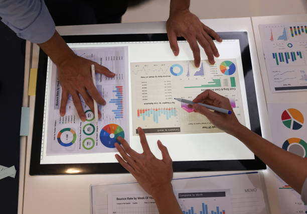 istock Close-up two managers discussing a business project on a bright screen with the paper report. 1556728125