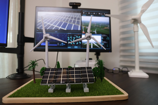 the professional property on a tablet with a black screen mock-up display. Creating a Concept of Wind Turbine and solar panel energy in an Office.