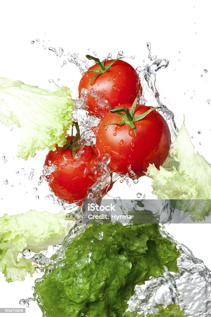 Trois des tomates rouges et salade verte avec de l'eau splash isolé - Photo de Légume libre de droits