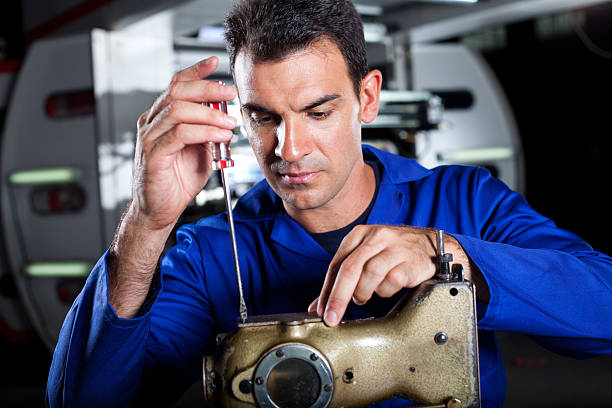 istock mechanic repairing industrial sewing machine 155674144