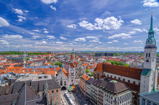 Elevated view over Munich and the Marienplatz with the St. Peters church on the right, the Heiliggeist church and the snow covered Alps in the far distance.