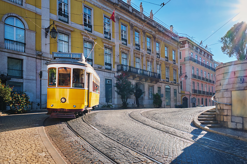 Famous vintage yellow tram 28 in the narrow streets of Alfama district in Lisbon, Portugal