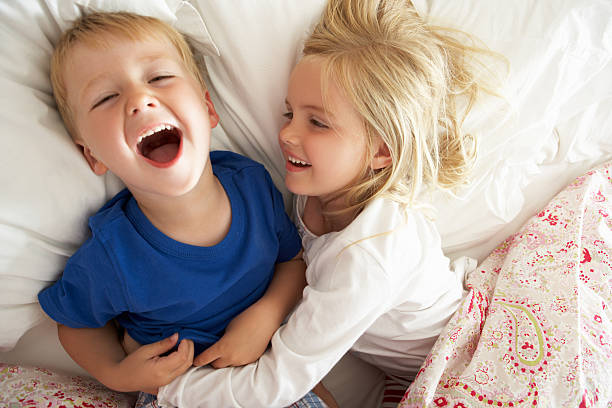 istock Brother And Sister Relaxing Together In Bed 155676714