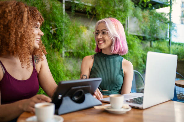 istock Modern women friends working together at cafe 1556786148