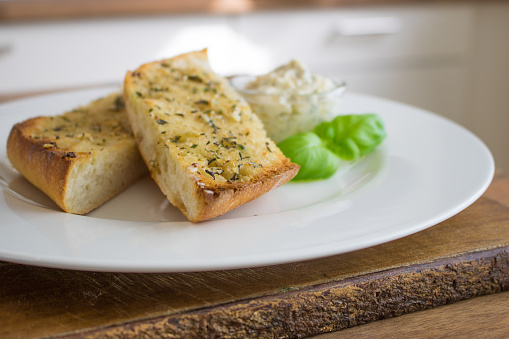 Food photgraphy of garlic bread with garlic butter on a white plate