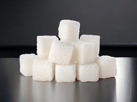 White sugar cubes on white background. Macro picture.