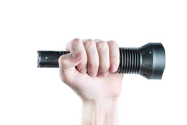 Flashlight in hand on white background stock photo