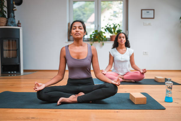 istock Beautiful Mixed Race Women Meditating Indoors 1556901353