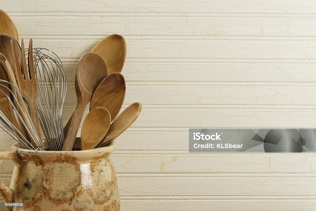 Wooden Spoons And Wire Whisks A collection of wooden spoons and wire whisks in an antique pot against a weathered wood background with copy space on right Antique Stock Photo