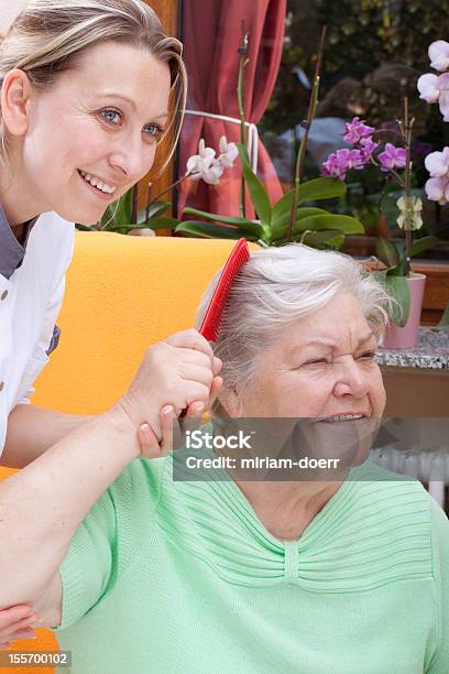 Personal De Enfermería Combs Hair De Un Senior Foto de stock y más banco de imágenes de 70-79 años - 70-79 años, Adulto, Alegre