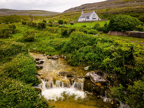 Scenic view of rural village church with stream landscape in Ireland greenland