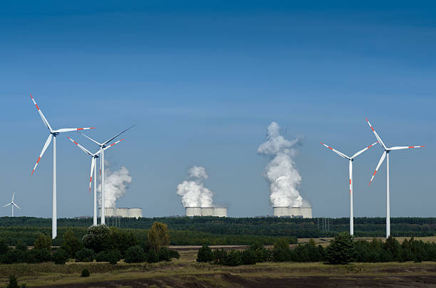 Wind turbines in front of a coal-fired plant stock photo