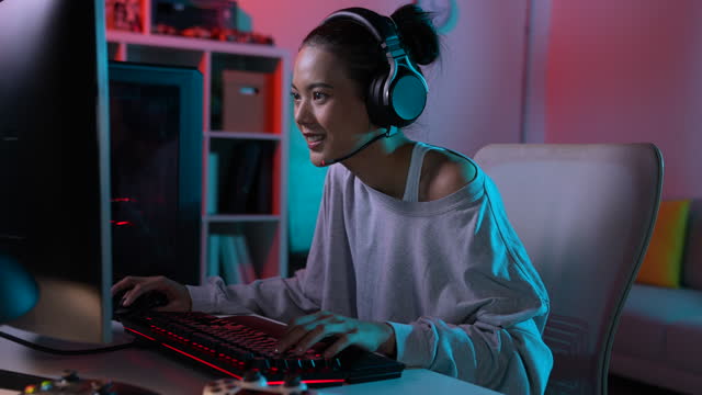 Happy young Asian woman playing a video game