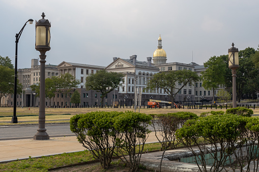 Trenton, New Jersey, USA- 05.14.2023: historic downtown. Trenton New Jersey. old architecture and government buildings. Trenton is the capital city of the U.S. state of New Jersey and the seat of Mercer County. It was the capital of the United States from November 1 until December 24, 1784.[24][25] Trenton and Princeton are the two principal cities of the Trenton–Princeton metropolitan statistical area, which encompasses those cities and all of Mercer County for statistical purposes and constitutes part of the New York combined statistical area by the U.S. Census Bureau.[26] However, Trenton directly borders the Philadelphia metropolitan area to its west, and the city was part of the Philadelphia combined statistical area from 1990 until 2000