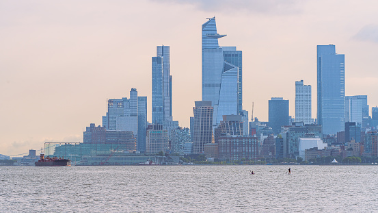 Hudson Yards and Chelsea Piers as seen from Liberty State Park in New Jersey with freight ships and kayakers in foreground