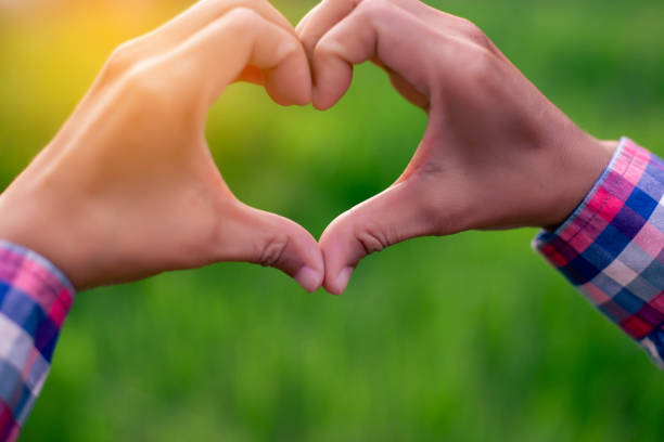 istock hands forming a heart shape with sunset silhouette SSTKHome 1557187160